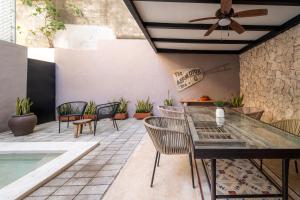 a patio with chairs and a table and a ceiling fan at Casa Balada Santa Lucía with Parking by Cercana in Mérida