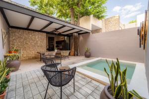 a patio with chairs and a swimming pool at Casa Balada Santa Lucía with Parking by Cercana in Mérida