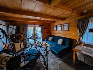 a living room with a blue couch and a table at Domki Widokowe Wooden Pod Gubałówką z Jacuzzi in Ząb