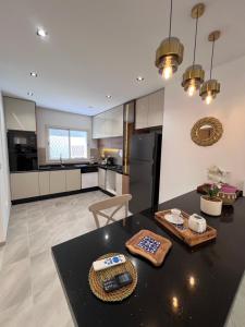 a kitchen with a black table and a black counter top at Résidences kenza in Kelibia