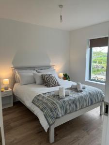 a white bedroom with a large bed and a window at Little Hills in Westport