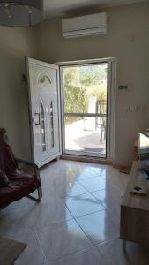 a living room with an open door with a patio at Aloe in Olympiada