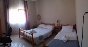 two beds in a small room with a window at Aloe in Olympiada