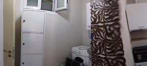 a small kitchen with a washing machine and a microwave at Aloe in Olympiada