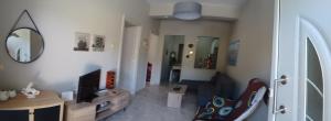 a living room with a couch and a tv and a mirror at Aloe in Olympiada