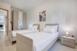 two beds in a hotel room with white walls at NEW - 2BR Beach side apt by SF HOMES in Sliema