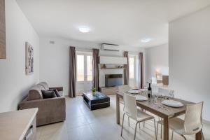 a living room with a dining table and a couch at NEW - 2BR Beach side apt by SF HOMES in Sliema