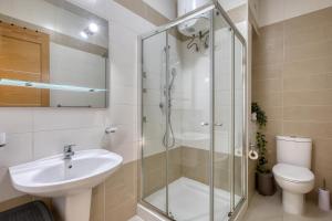 a bathroom with a shower and a sink and a toilet at NEW - 2BR Beach side apt by SF HOMES in Sliema +31 photos