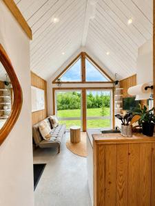 ein Wohnzimmer mit Sofa und großem Fenster in der Unterkunft Nature Getaway with Lake, Horseback Riding & BBQ in Sainte-Marguerite