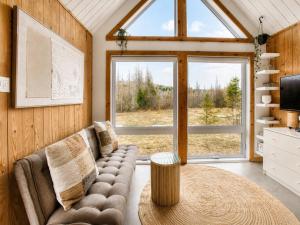 ein Wohnzimmer mit Sofa und großem Fenster in der Unterkunft Nature Getaway with Lake, Horseback Riding & BBQ in Sainte-Marguerite
