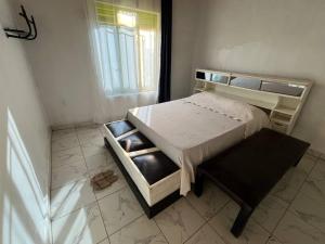 a small bedroom with a bed and a window at Blue Home Stay in Janjagiro