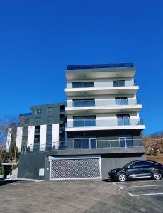 a black car parked in front of a building at Apartman Eldin Panonika in Tuzla