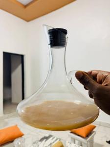 a person holding a glass vase with liquid in it at Blue Home Stay in Janjagiro +54 photos