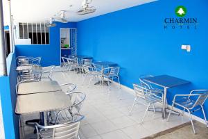 a room with blue walls and tables and chairs at Hotel Charmin in Gaira