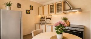 a kitchen with a table with a vase of flowers at Seaside Apartments - Vasilije in Baošići