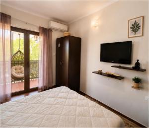 a bedroom with a large bed and a flat screen tv at Seaside Apartments - Vasilije in Baošići