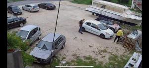 a group of cars parked in a parking lot with a boat at Seaside Apartments - Vasilije in Baošići