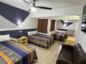 ein Hotelzimmer mit zwei Betten und einer Couch in der Unterkunft Hotel Nueva Zelanda in León