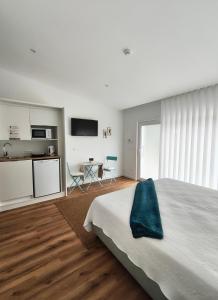 a bedroom with a bed and a kitchen and a table at Hotel de Charme Casa Fundevila in Vila Verde