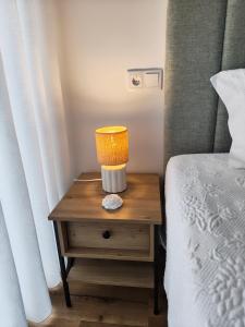 a table with a lamp on it next to a bed at Hotel de Charme Casa Fundevila in Vila Verde