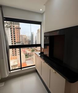 a room with a large window and a large television at Itapema in Itapema