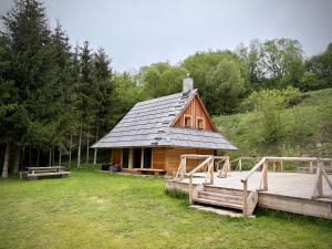a log cabin with a porch and a wooden deck at Górska Osada Berdo in Chmiel