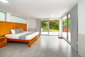 a bedroom with a large bed and large windows at Casa campestre en el Eje Cafetero in Circasia +43 photos
