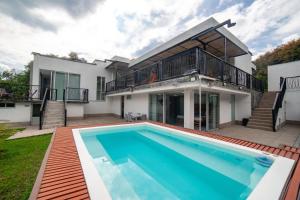 a house with a swimming pool in front of a house at Casa campestre en el Eje Cafetero in Circasia