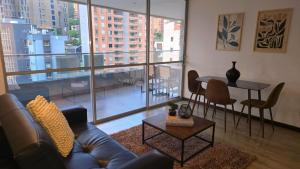 a living room with a couch and a table at Apartamento terraza hamaca - doble parqueadero - Provenza in Medellín