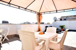 a patio with a white table and chairs at CasaKami Sky Terrace in Nettuno