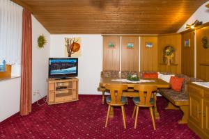 a dining room with a table and a tv at Appartement Hochleitner in Wagrain