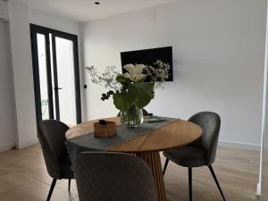 a dining room table with chairs and a vase of flowers at Apartamento Casa Nela 3 in Medellín