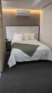 a bedroom with a large bed with a large headboard at Suites André Confort Ejecutivo in Aguascalientes