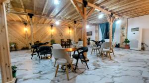 a large room with tables and chairs on a stone floor at Sweet Home Aria in Çorovodë