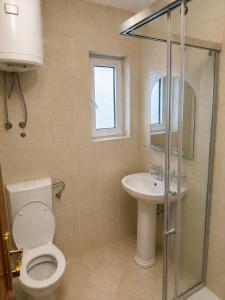 a bathroom with a toilet and a sink at M Apartments 2 in Bar