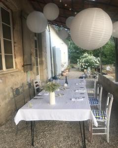 a table with a white table cloth and white lanterns at Pavilion de LaFue in Lavergne