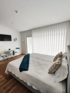 a bedroom with a large bed with blue pillows at Hotel de Charme Casa Fundevila in Vila Verde