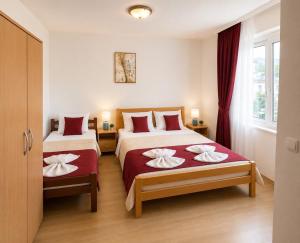 a bedroom with two beds with red and white sheets at M Apartments 2 in Bar