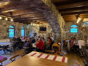 a group of people sitting at tables in a restaurant at Bujtina Lepushe Agroturizem in Lëpushë +17 photos