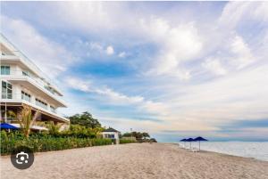 a building on the beach next to the ocean at Hostel HM Caribe in Santa Marta
