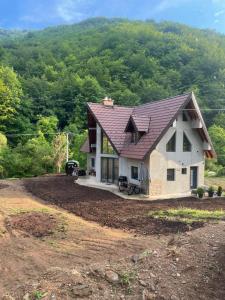 a house with a roof on top of a field at Ćilibar Stara planina in Crni Vrh