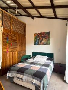 a bedroom with a bed and a painting on the wall at Floripa Beach House Hostel in Florianópolis