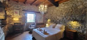 a bedroom with a bed and a stone wall at El Juacu in Llanes +67 photos