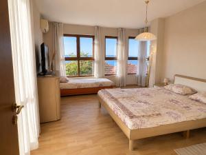 a bedroom with two beds and a large window at Villa Bella Sozopol in Sozopol