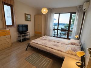 a bedroom with a large bed and a television at Villa Bella Sozopol in Sozopol