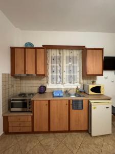 a kitchen with wooden cabinets and a sink and a refrigerator at Dream Catcher 5 in Agia Theodoti