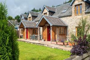 a large house with red doors and a yard at Elm Cottage in Aberfeldy