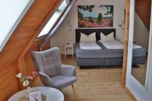 a bedroom with a bed and a chair and a table at Naturhotel Hof Ehlers in Bergen +61 photos