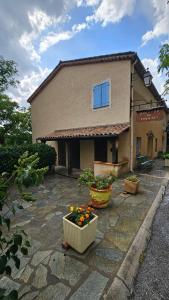 a house with two potted plants in front of it at Auberge du Coustet in Saint-Léger