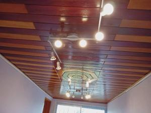a room with a wooden ceiling with lights on it at Hôtel amsterdam in Douala